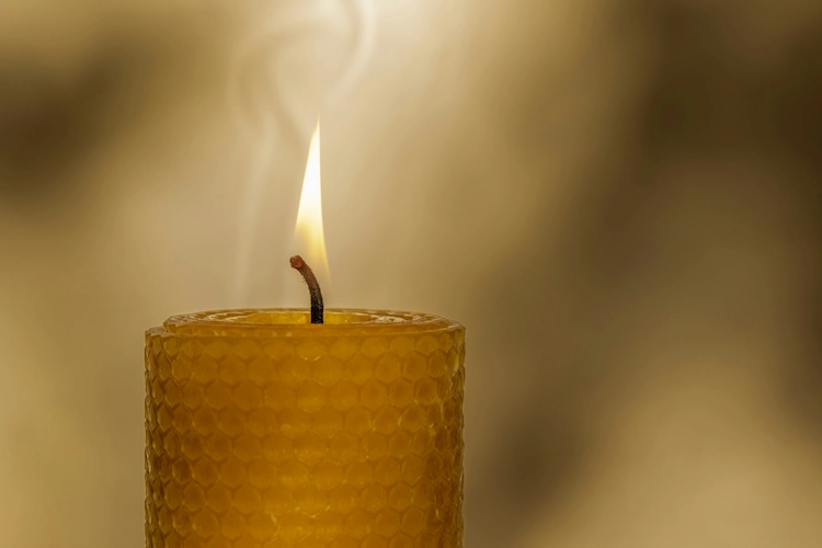 Vela de cera de abeja encendida